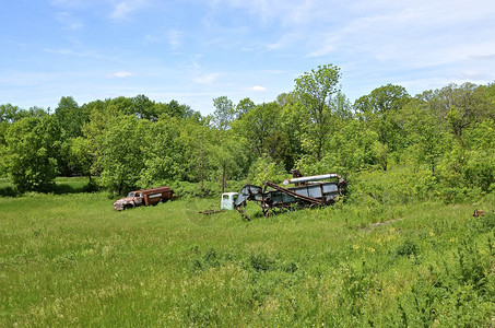 在树林边缘停泊的车是一台老式推车一辆燃料卡车和一图片