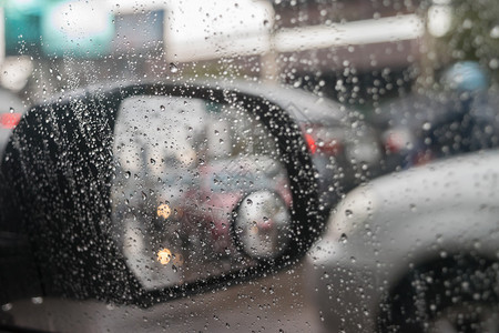 车后视镜和雨水滴与交通反射背景图片