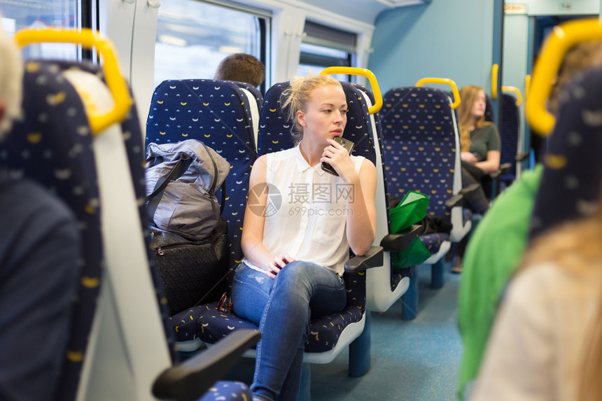 年轻女子在火车上旅行时仰望图片
