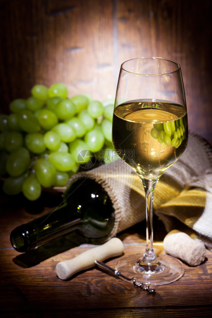 葡萄酒瓶葡萄和白葡萄酒杯放在图片