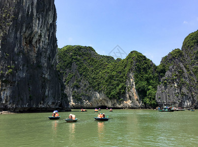 蓝天越南哈隆湾与旅游者贡多拉图片