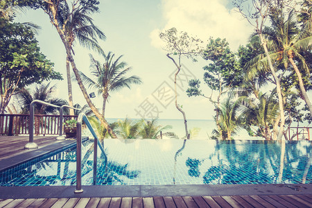 美丽的豪华雨伞游泳池和椅子在酒店度假村的海滩和大海附近的游泳池周围图片