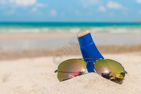 白色沙滩上的太阳镜和防晒霜图片