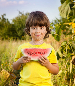 在花园里吃西瓜快乐的小孩在图片