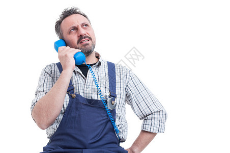 严肃的修理工解决电话工作问题的肖像图片