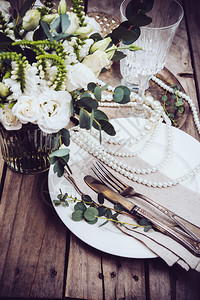 古老的婚礼桌装饰餐具和珍珠花束和红酒杯图片