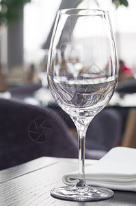 餐厅木桌上的一个酒杯图片