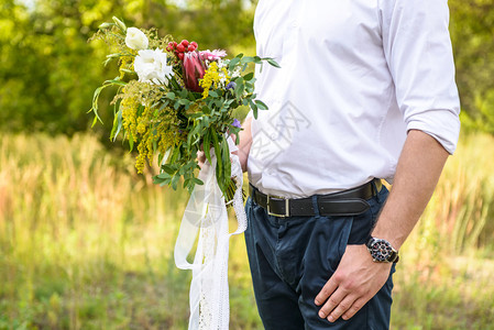 新郎手里拿着婚礼花束图片