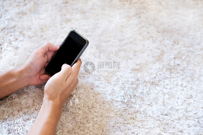 在白地毯上使用智能手机的手有图片