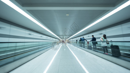 机场隧道配有平式扶梯的轻型行走道和携带行李的人图片