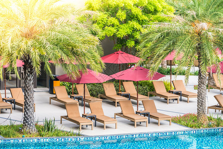 酒店和度假胜地游泳池附近的伞状和椅子图片