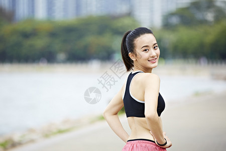年轻的亚洲女子跑步者在跑步前转身看着相机图片
