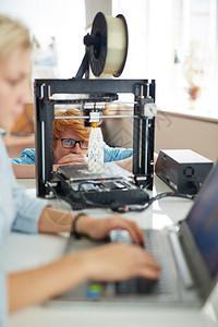 工程师在工作环境中研究3D打印机建筑模型的3图片