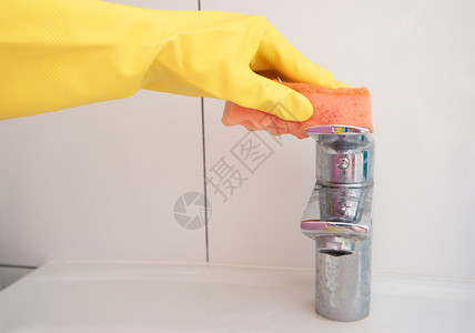 在洗手间清洁一个脏水龙头用橡胶手套和海图片