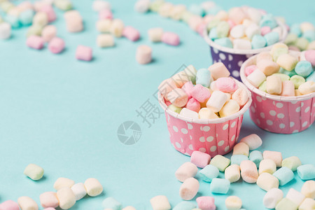 五颜六色的糖果背景小彩色棉花糖蓝色桌子选择焦图片