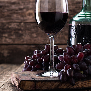 一杯红酒配上木制背景的葡萄图片