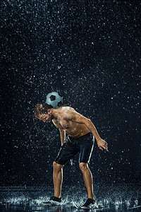 黑色背景下足球运动员周围的水滴图片