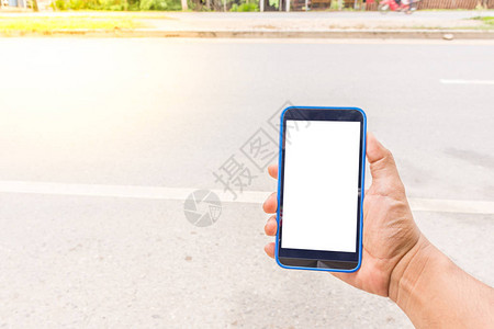 手持智能手机或带白色屏幕的手机的人在路上使用图片