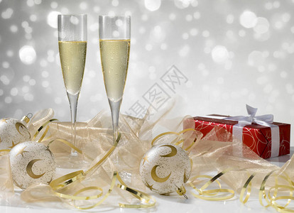 两杯香槟金装饰品红礼带白丝带背景图片