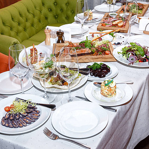 餐桌上有沙拉和海产食品开胃菜以及餐厅木制图片