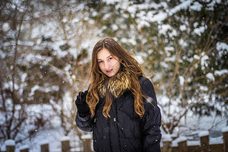 在雪背景微笑的长头发的女孩特写图片