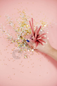 以粉红背景为新年用女手拿的带有稻草图片