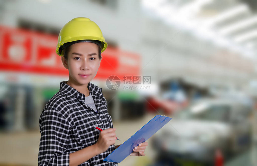 亚洲女工程师和技术员机械师正在汽车修理店检查和检查汽图片