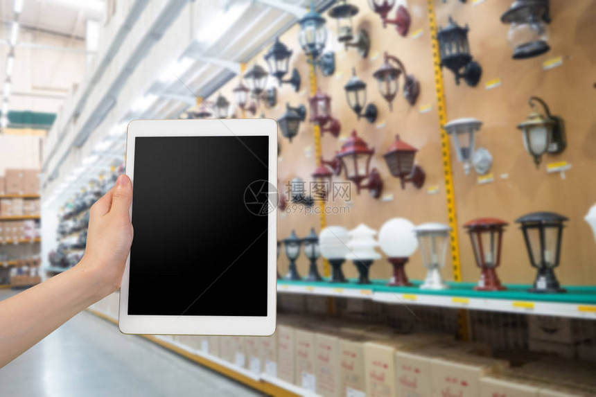 人的手握空白的屏幕智能手机平板电脑模糊灯店商的空白屏幕手机购物室图片