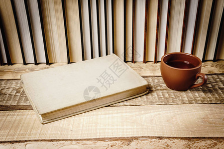 看书的封面和木架子上的一杯热茶图片
