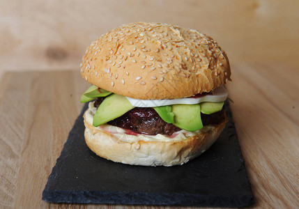 汉堡塞在板块底座上玻璃和餐具装在木板上图片