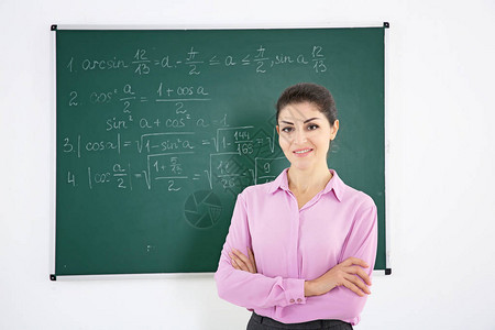 白色背景黑板旁的年轻女教师图片