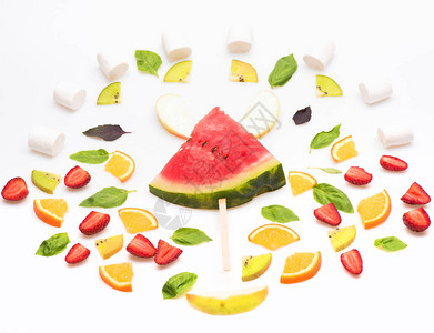 白色背景中突显的橙色水果西瓜片猕猴桃草莓和绿薄荷图片