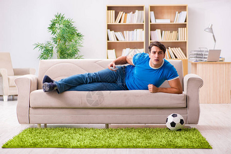 男人坐在沙发上在家看足球图片