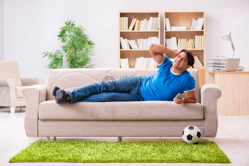 男人坐在沙发上在家看足球图片