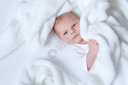 可爱的新生婴儿躺在白色的床上图片