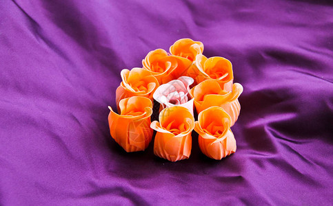 紫色丝绸背景上的玫瑰形肥皂图片