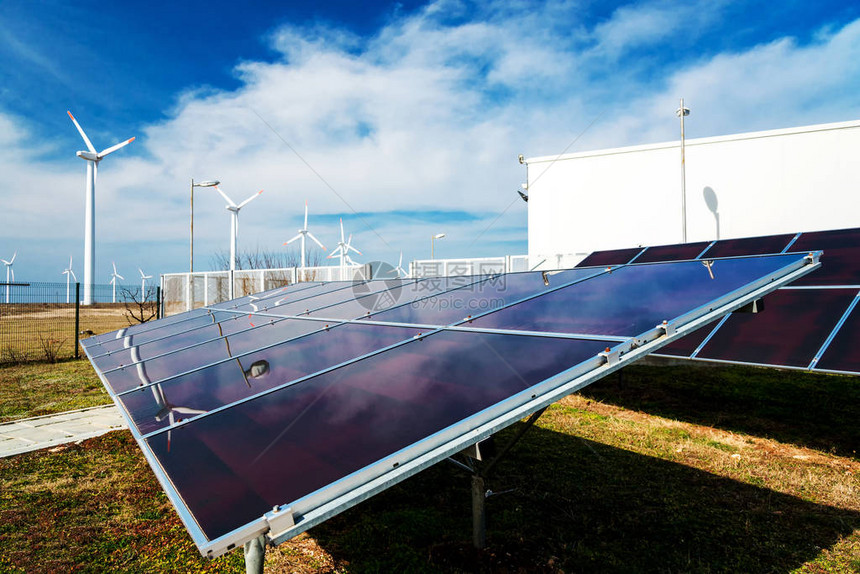 电站与风力涡轮机背景对比的太阳能电池板可图片