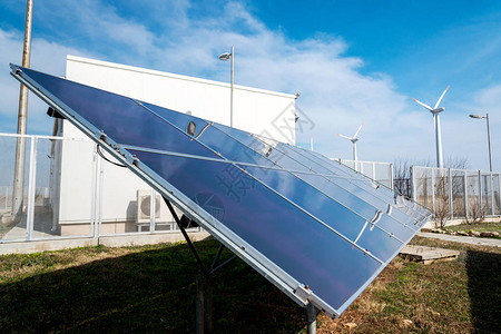 电站与风力涡轮机背景对比的太阳能电池板可图片