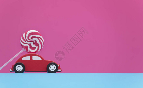 红色小车形状的玩具粉红背景图片