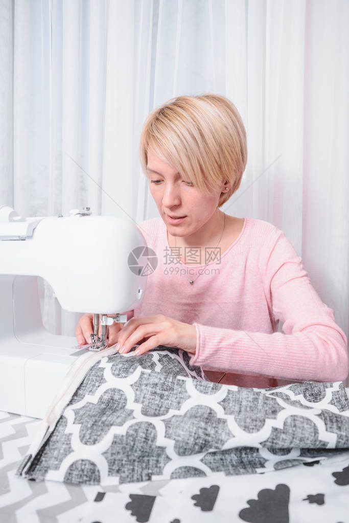 美丽的女裁缝在纫机上缝衣服缝纫车间图片