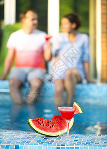 情侣在泳池边喝西瓜玛格丽塔图片