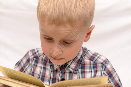 一个5岁的男孩在床上读书表达情感图片