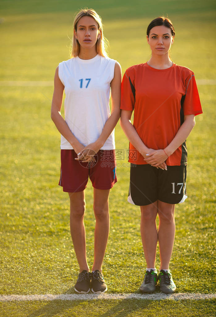 两名身穿足球制服的女孩站在足球场上等待惩罚踢球图片