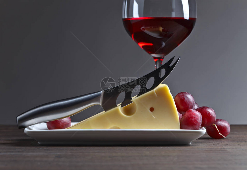 奶酪一杯红酒和刀子在图片