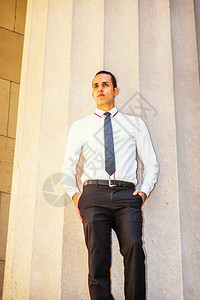年轻美国商人身穿白衬衫黑领带手插口袋站在纽约办公大楼外面图片