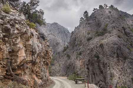 土耳其Goyynuk峡谷远山近山岩石树木山路长板绳围栏和灰色风图片