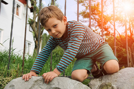 穿条纹毛衣和短裤的小男孩在阳光图片