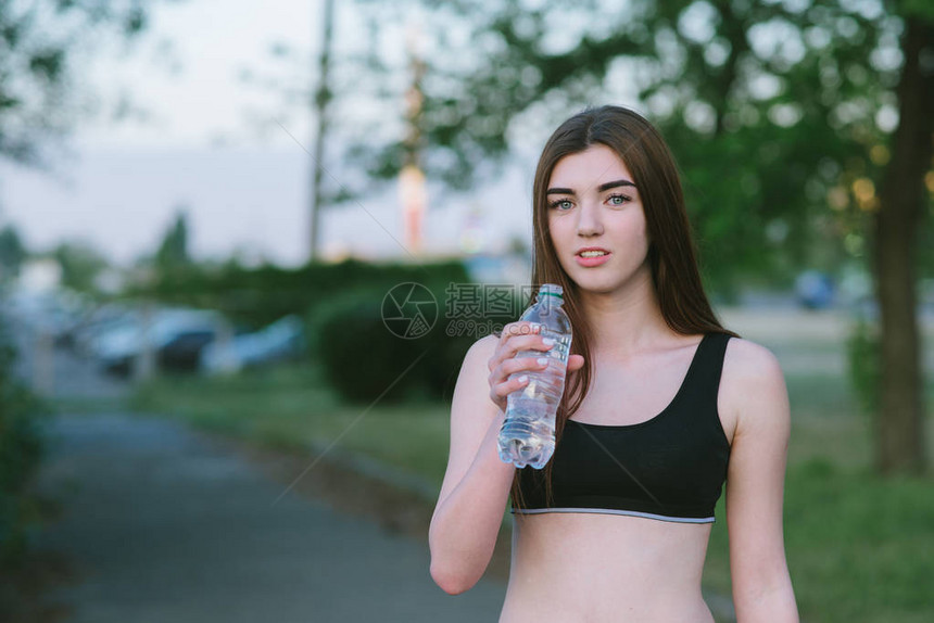 美丽的年轻女孩身体健康手拿着水瓶图片