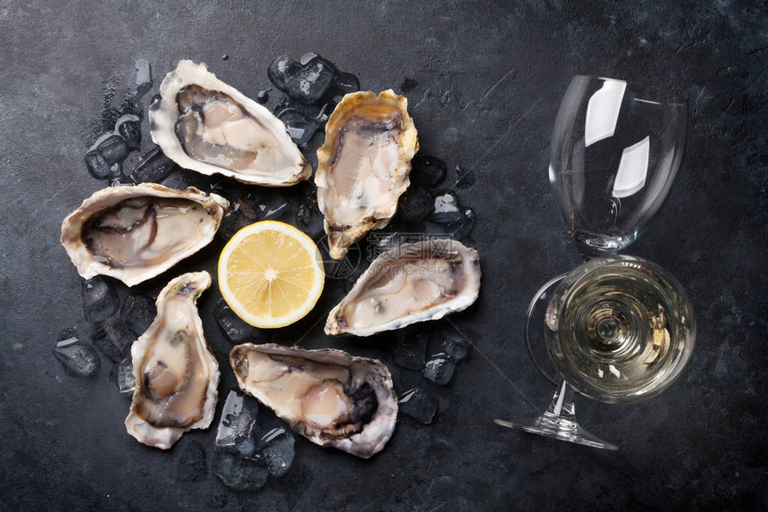 石桌上打开的牡蛎冰柠檬和白葡萄酒图片