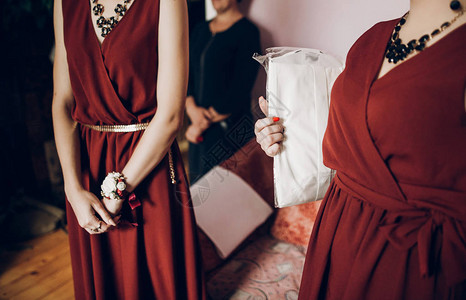时髦的伴娘穿着红裙子和布顿尼耶尔花背景图片
